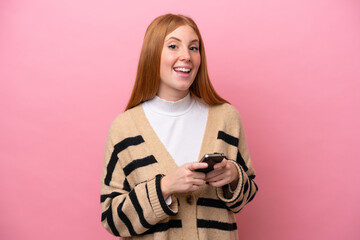 Fototapeta premium Young redhead woman isolated on pink background surprised and sending a message