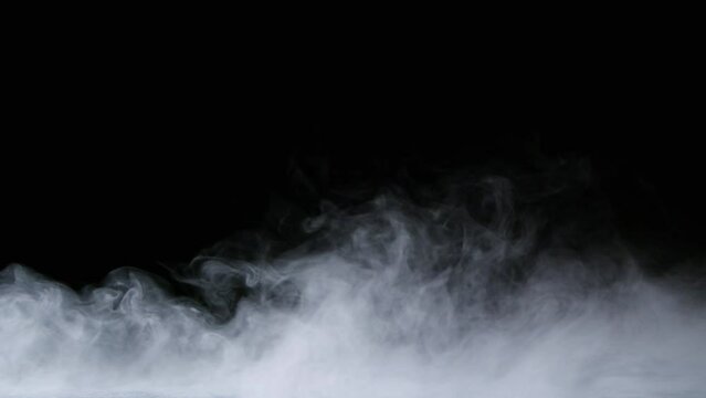 Slow motion of white smoke, fog, mist, vapor on a black background