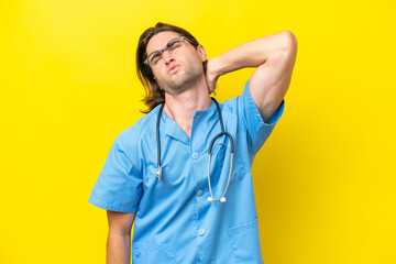 Young surgeon caucasian man isolated on yellow background with neckache