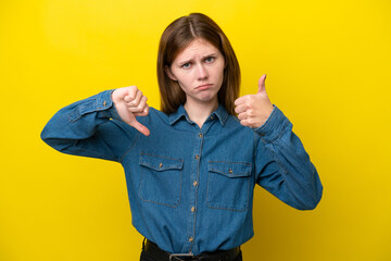 Young English woman isolated on yellow background making good-bad sign. Undecided between yes or not