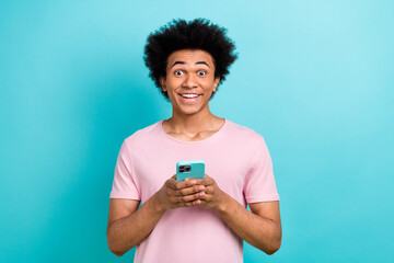 Portrait of young surprised man funny hairstyle chevelure hold his iphone amazed new web game...