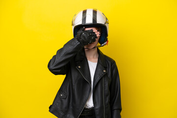 Young English woman with a motorcycle helmet isolated on yellow background covering eyes by hands. Do not want to see something
