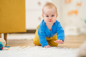 Caucasian baby toddler crawls on all fours around the room