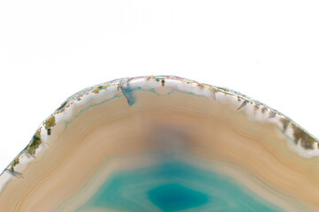 White and light Blue semi-transparent agate slice crystal, banded chalcedony stone isolated on a white background surface. Abstract light crystal image with lots of copy space