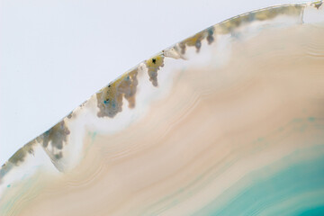 White and light Blue semi-transparent agate slice crystal, banded chalcedony stone isolated on a white background surface. Abstract light crystal image with lots of copy space