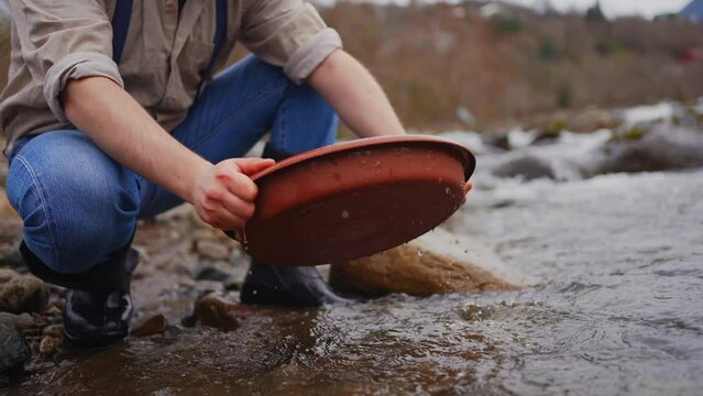 Panning for gold in a creek bed Panning mining and extraction in river
