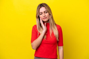 Young Uruguayan woman isolated on yellow background with toothache