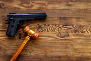 Hand gun weapon and judges gavel - gun law. Illegal use of weapons concept