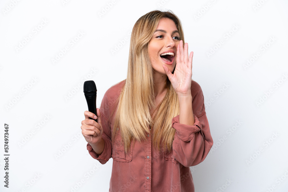 Wall mural singer uruguayan woman picking up a microphone isolated on white background shouting with mouth wide