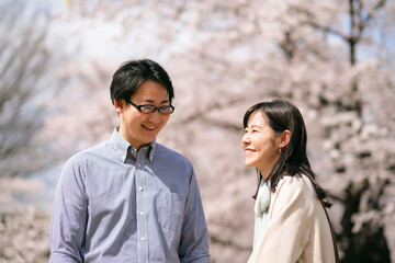 満開の桜の下で話をするカップル
