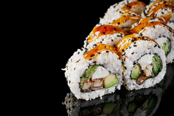 sushi roll with sesame avocado cucumber eel and Philadelphia cheese on a black mirror background