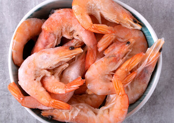 Shrimps in bowl. Frozen boiled seafood product. Top view. Close-up