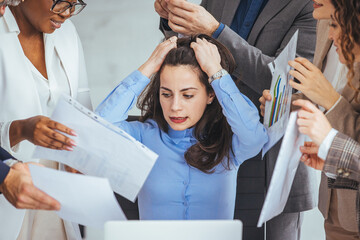 Frustrated millennial female worker sitting at table with colleagues, felling tired of working...