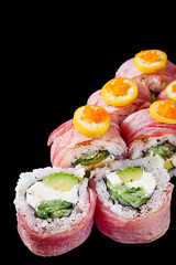 sushi roll with cream cheese, grilled tuna, cucumbers, avocado on a black mirror background