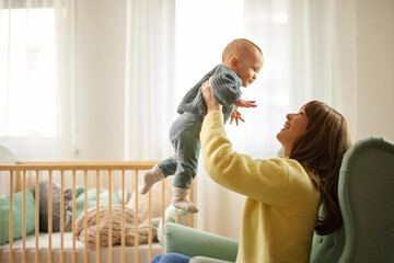 Portrait of beautiful young mother holding her baby boy in her arms