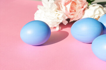 Easter eggs in blue on a pink background with flowers.