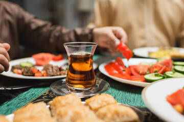 turkish tea glass near food and muslim boy during ramadan dinner.