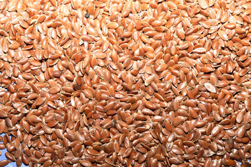 Linseed, brown seeds throughout the frame, background.