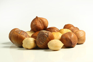 Hazelnuts, raw, peeled, in shell and roasted on white backround