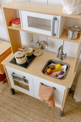 Children's wooden kitchen with toy food items