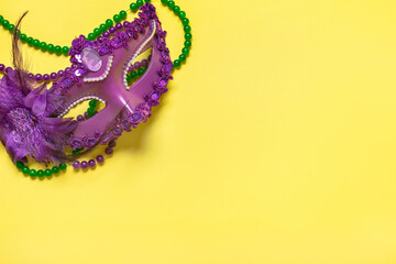 Mardi gras concept. Congratulation card with violet mask on yellow background Top view 2023 Mardi...