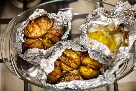 freshly cooked baked potatoes. Potatoes with bacon and garlic in foil. cooking food in the oven. top view