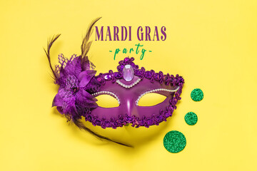 Mardi gras concept. Congratulation card with violet mask on yellow background Top view 2023 Mardi...