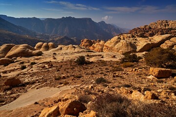 Jordan sunset landscape. Rocky mountain with orange evening in Dana Biosphere Reserve, Jorda. Traveling in Arabia. Stones and valley in Dana nature, wildlife. - obrazy, fototapety, plakaty