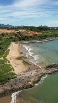 Imagem aérea da Praia do Morro e Praia da Cerca, na região central de Guarapari. Esportes na praia e na água como canoa havaiana e corrida.