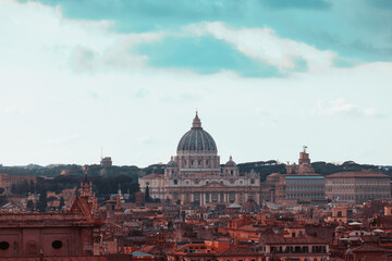 Fototapeta na wymiar Romantic view of Rome with St Peter's Basilica (San Pietro) in Vatican City, Italy at sunset. It is a famous landmark of Vatican. Nice cityscape of the old Roma in winter