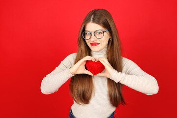 Portrait of a blood donor woman holding a red heart in her hands.