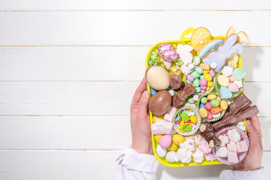 Easter charcuterie board. Sweet Easter party, kids holiday treats assortment - chocolates, easter eggs, marshmallows, candies, chocolate bunny, snacks and treats tray