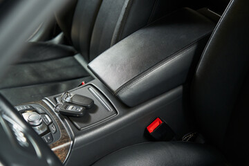 leather car armrest, keys lying on a hidden storage box
