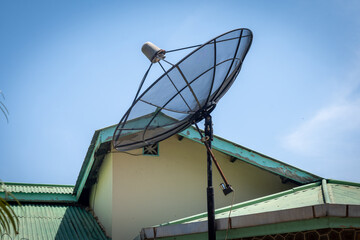 Big C-Band Satellite dish on roof of a house. Option to get free cable TV signal.