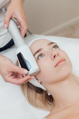 Naklejka premium Cosmetologist uses device on a female face