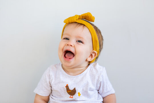 happy aussie baby girl laughing with big smile on white copy space background