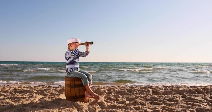 Child looking through spyglass. Summer vacation and travel concept. Slow motion