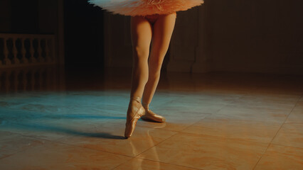 Cinematic close up shot of graceful ballet dancer feet in pointe shoes and white tutu. Female...