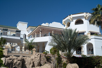 Palm trees against white home by the beach with blue sky and sand The top of the house or apartment with nice window