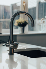 Close up photo of a chrome kitchen tap with marble sink, fawcet sink water drip interior design