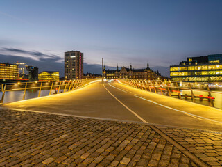 Lille Langebro cycle and pedestrian bridge over the city harbour lit up after sunset in Copenhagen, Denmark