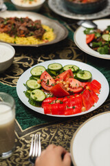 Cropped view of kid near fresh vegetables and iftar food at home.