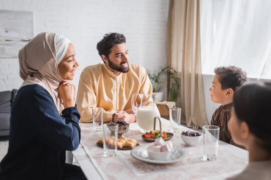 Muslim Man Holding Prayer Beads Near Family And Ramadan Breakfast At Home.