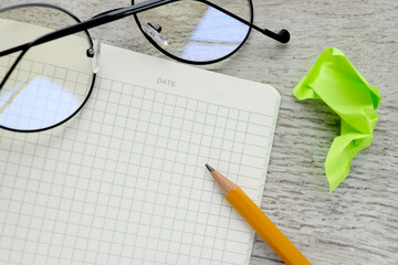 Blank notepad page with space for text, pencil and glasses. Minimum workspace. View from above.