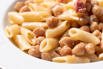 Piatto di saporita pasta con ceci e pancetta, cibo italiano 