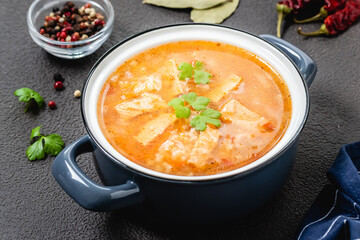 Georgian lamb kharcho soup in pot on dark background. Top view, copy space, flat lay.