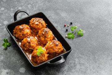 Thai sweet chili turkey meatballs in cast iron skillet on dark background. Top view, copy space, flat lay.