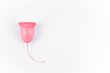 Pink menstrual cup on a white background. Alternative feminine intimate hygiene product. Women's...