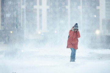 silhouette of a man walking in a snowstorm in the city the concept of a storm blizzard and bad...