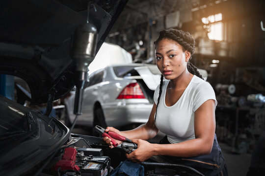 Car Machanic is maintenance on the car in the garage. checking and change the battery. Car maintenance concept.